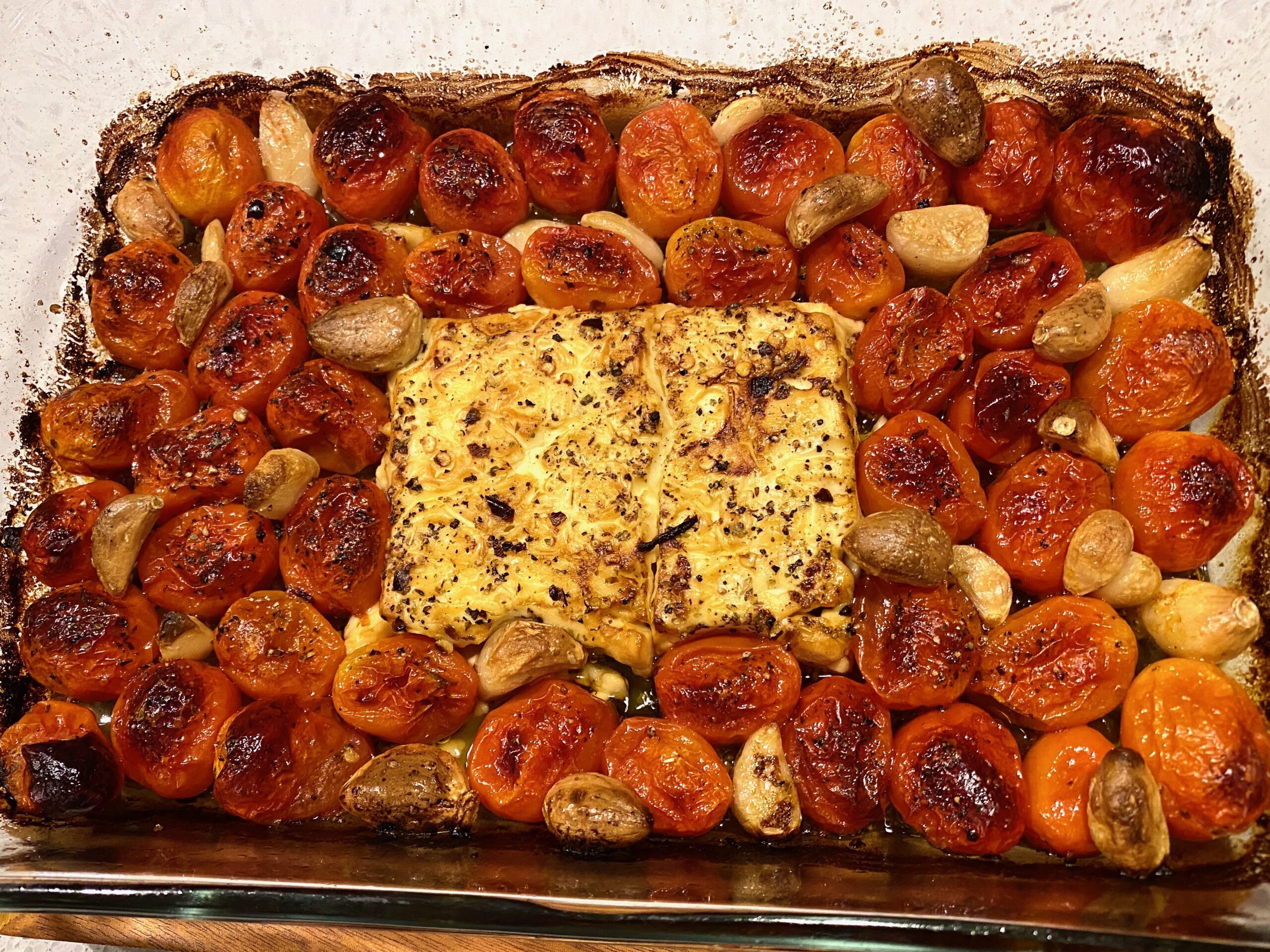Image of a baking dish with golden brown baked feta and tomatoes