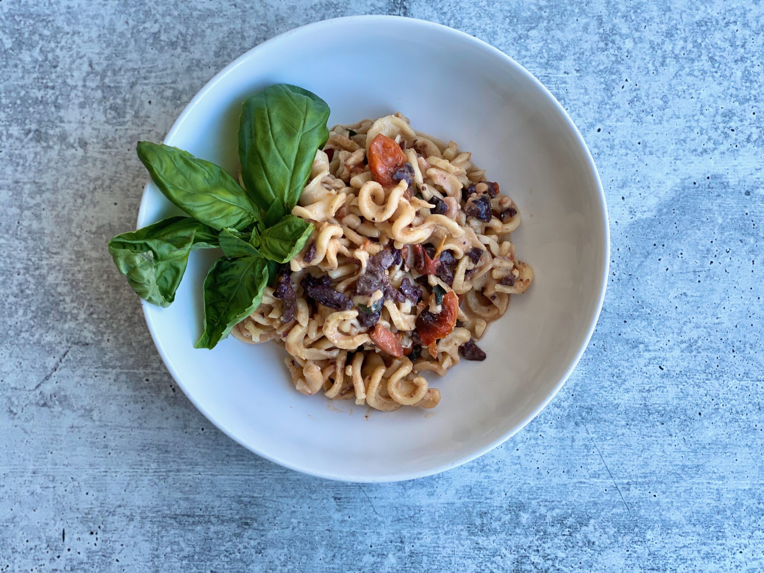 Image of pasta in a bowl with a basil garnish