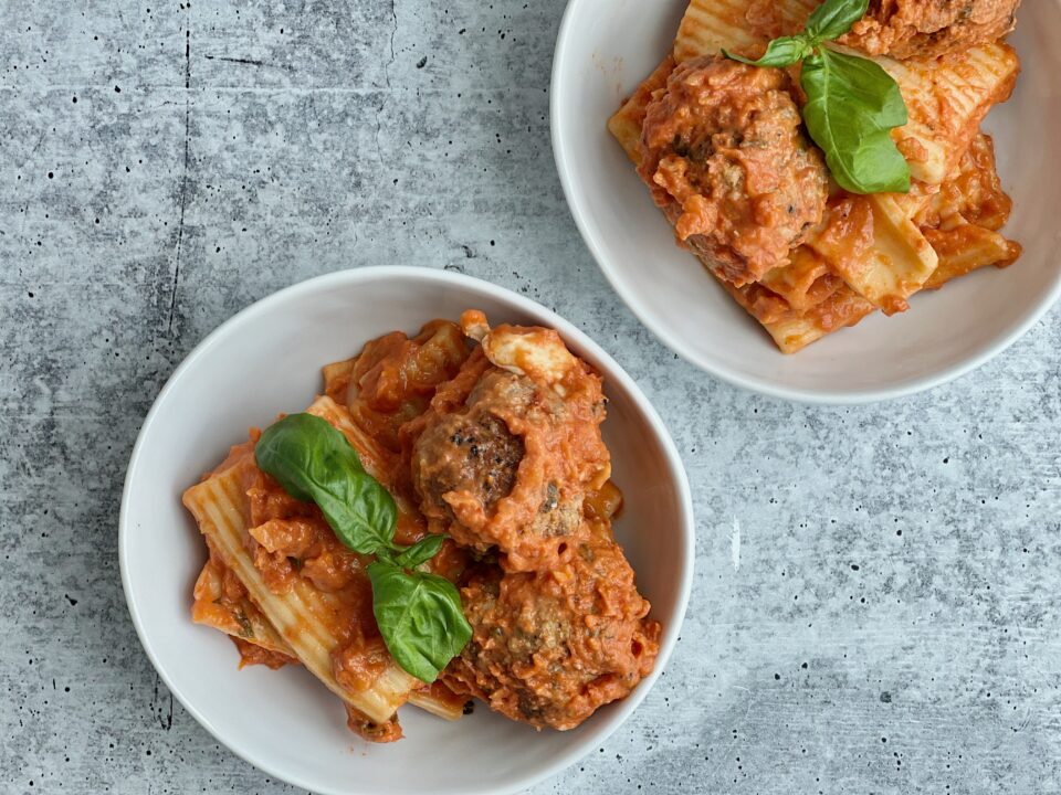 Meatballs with Tomato Cream Sauce Two bowls filled with pasta and meatballs