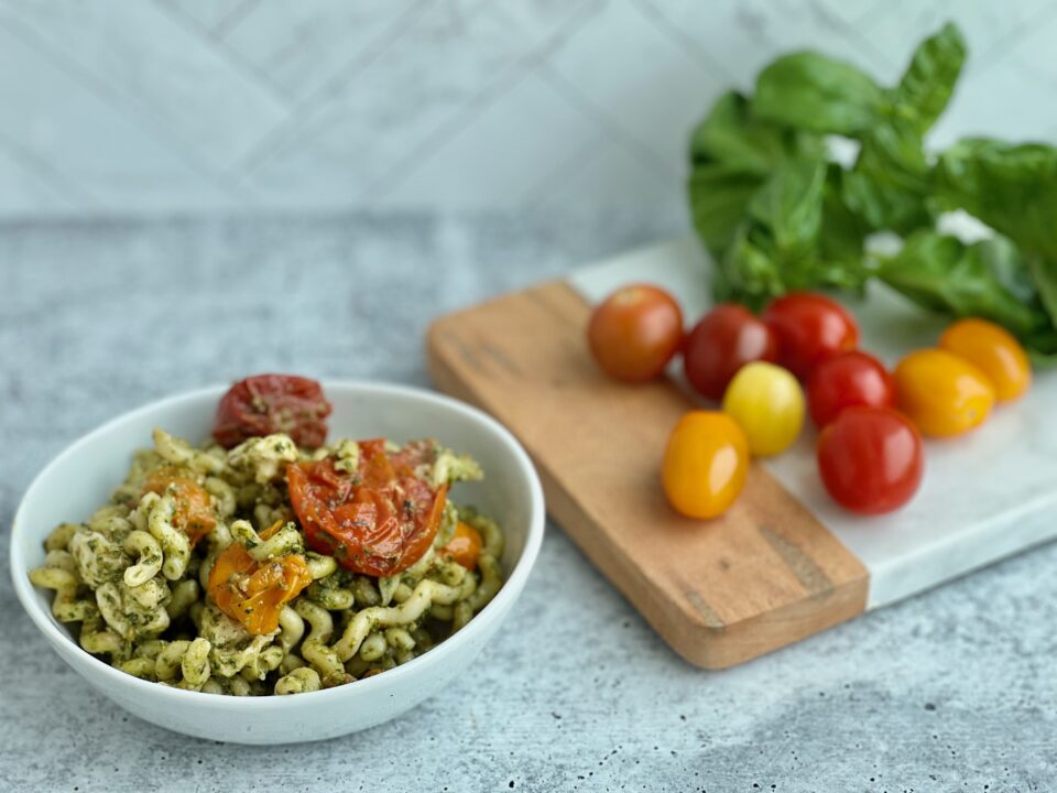 Easy Pesto Pasta with Roasted Tomatoes A bowl of pesto pasta with roasted tomatoes in it