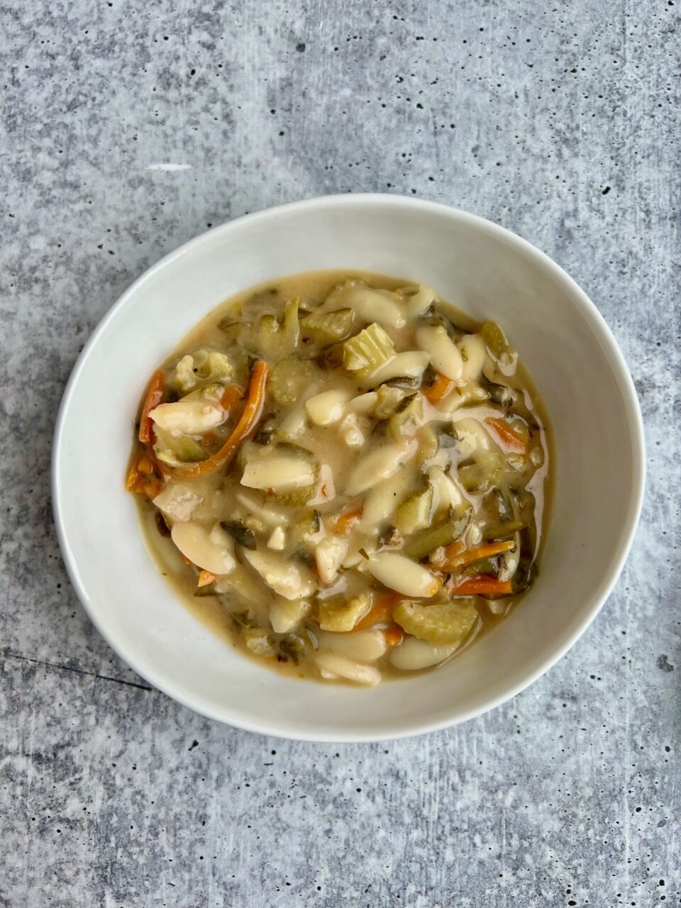 Creamy Lemon Orzo Soup A bowl of creamy lemon orzo soup with lemons in the background