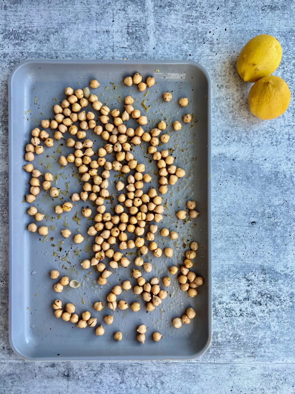 Vegetarian Greek Bowls with Halloumi A cookie sheet with chickpeas and lemons